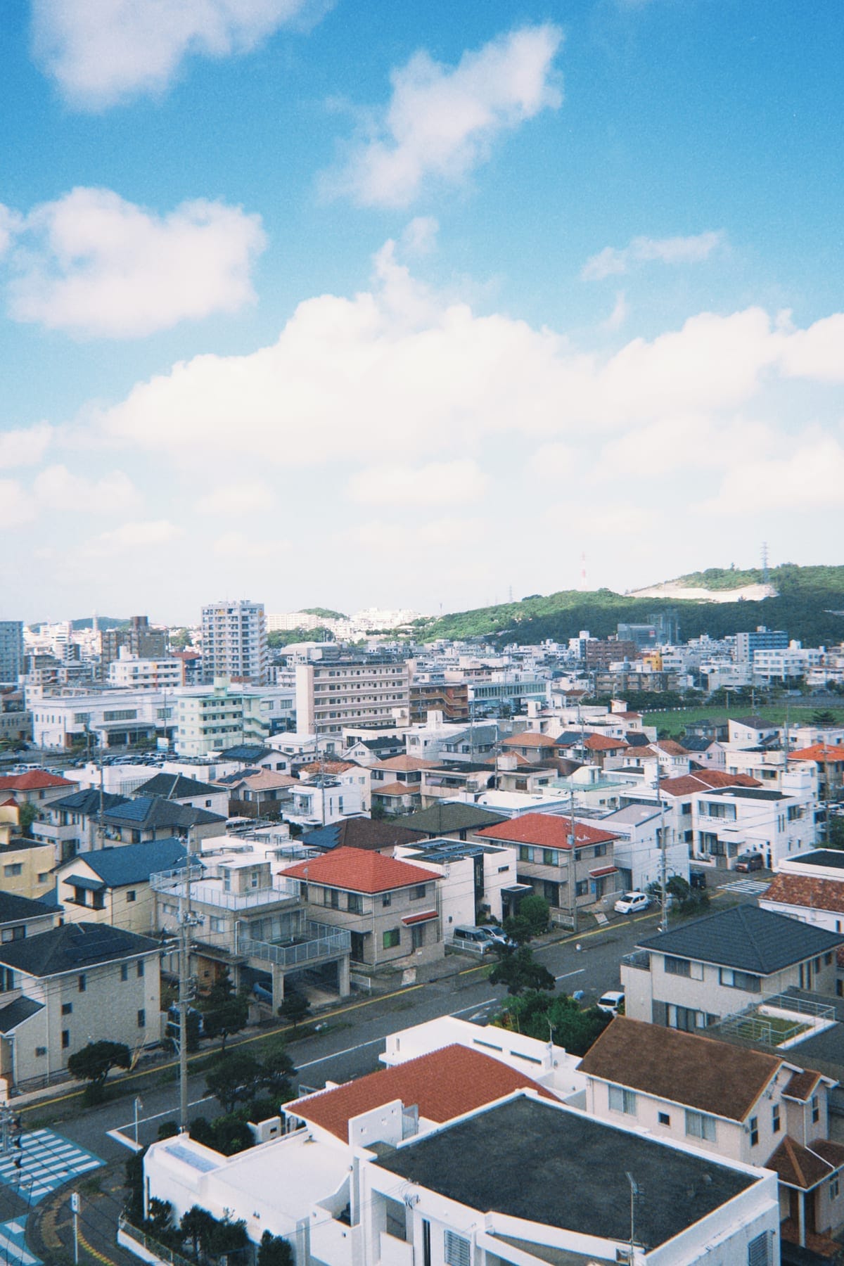 Okinawan rooftops stepping down toward the sea